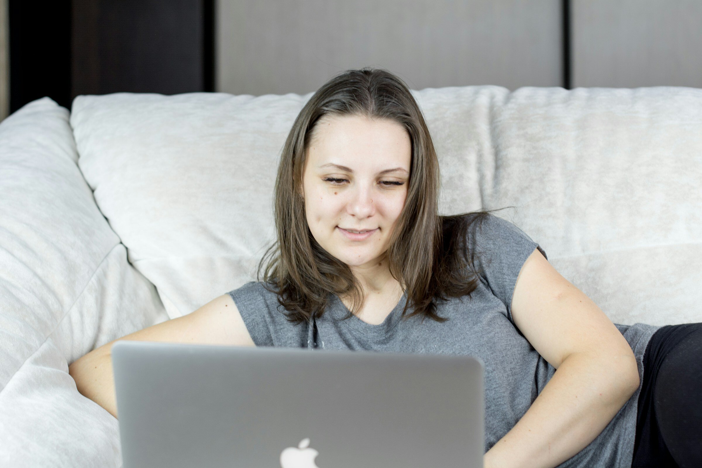 woman laying on bed and using Logicmonitor Alternatives