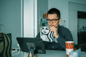 person working and drinking coffee - Node.js Application Monitoring